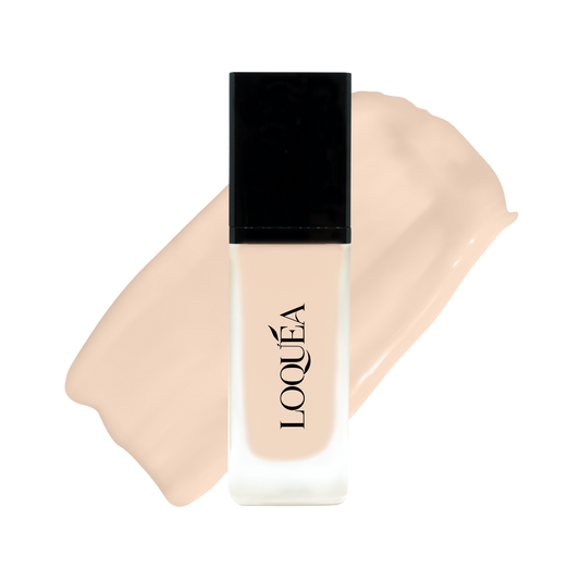 A bottle of LOQUÉA liquid foundation with a black cap, shown in front of a swatch of the beige foundation shade on a white background.